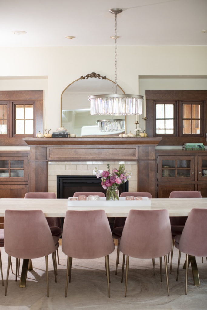 Dining room with pink velvet chairs, white table and wood built ins
